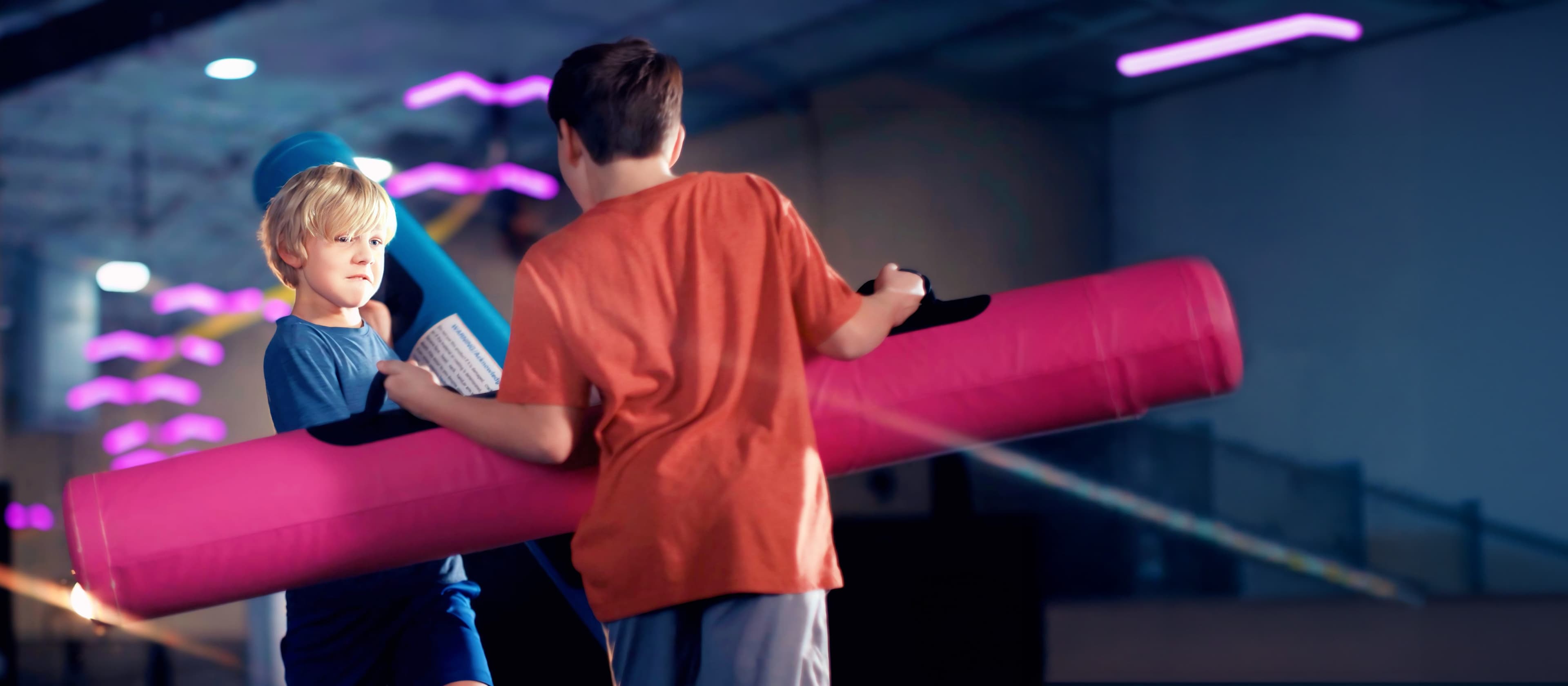 Two kids playing on the battle beam at Urban Air