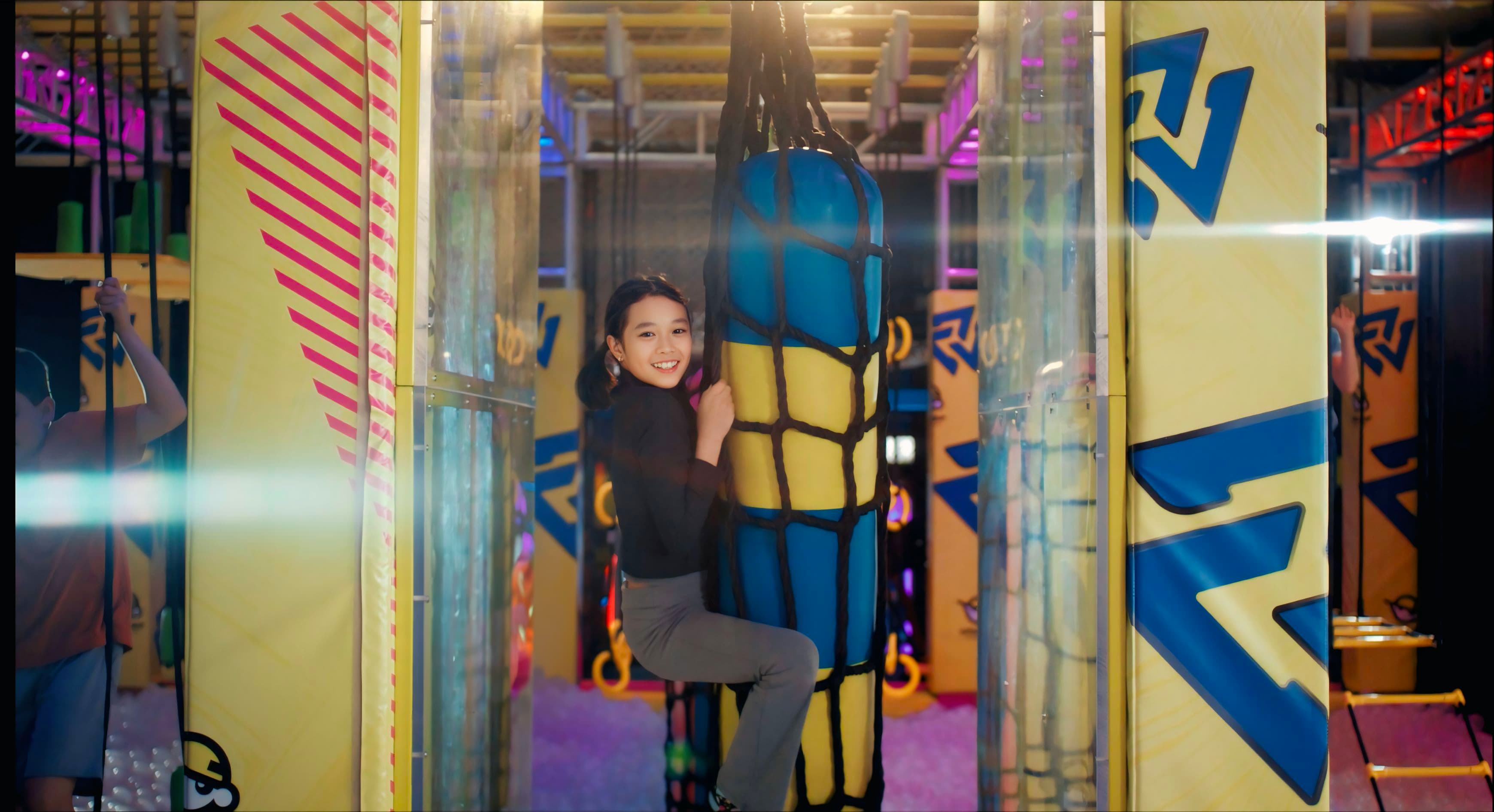 A girl climbing the warrior course at Urban Air